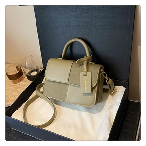 Détail du sac à bandoulière en cuir vert dans un coffret cadeau noir de prestige