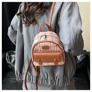 Detail view of mini plaid backpack with leather trim and decorative Fashion patch