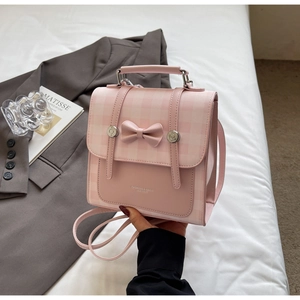 Detail of pink plaid backpack with bow decoration and leather fashion engraving