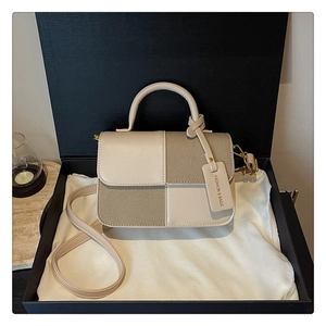 Détail du sac à bandoulière bicolore dans un coffret cadeau avec cuir et tissu premium