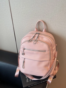 Pink lychee grain leather backpack with jacquard straps and multi-pocket storage design