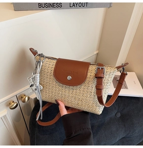 Detail einer gewebten Stroh-Schultertasche mit Lederbesatz und geprägtem Markenlogo