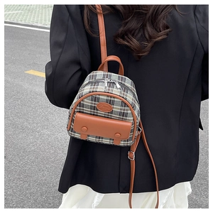 Detailed back view of a mini plaid backpack worn with a black blazer and white skirt