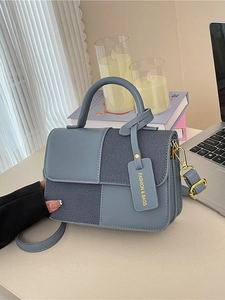 Sac bandoulière bicolore chic en cuir bleu clair et denim foncé avec des ferrures dorées