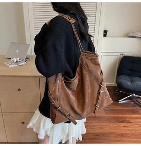 Retro brown PU leather tote bag detail showing side metal buckle and vintage texture