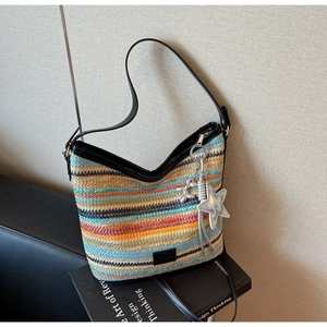 Detalle de bolso cubo tejido bohemio con rayas coloridas y un colgante de estrella