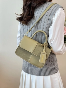 Sac bandoulière patchwork vert olive en tissu et cuir porté par un mannequin