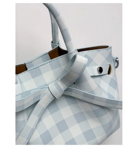 Vue détaillée du sac à main vichy bleu avec texture tissée, nœud et doublure marron