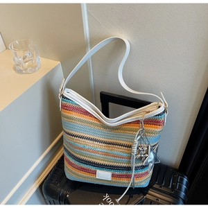Detalle de bolso bandolera tejido a rayas de colores con colgantes de estrellas