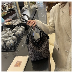 Detailed view of dark leopard print bucket bag with long black leather handles