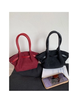 Detail of burgundy and black suede tote bags with expandable wing design and handles
