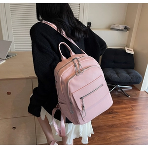 Detail of pink lychee leather backpack with adjustable geometric textured straps