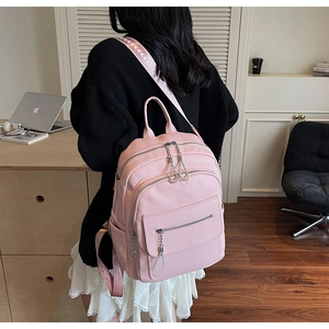Pink lychee texture leather backpack with multi-zipper pockets and rhinestone chain details