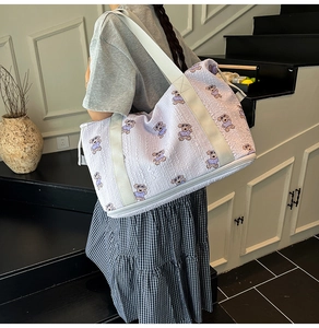 Detail view of purple travel bag featuring bear patterns and a separate shoe compartment