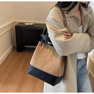 Detail of quilted bucket bag featuring khaki suede texture and golden metal twist lock