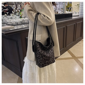 Detail of grey leopard print hobo shoulder bag with textured finish and black strap