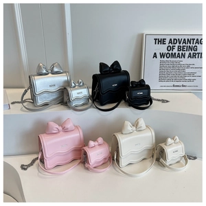 Close-up of mini bow crossbody bags in silver, black, pink, and beige with chain straps
