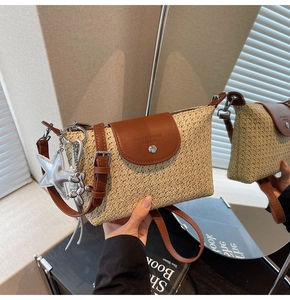 Detail der Strohtasche mit brauner Lederklappe und silbernem Sternanhänger