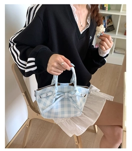 Détail du sac à main vichy bleu clair avec nœud et bandoulière élégante pour femme