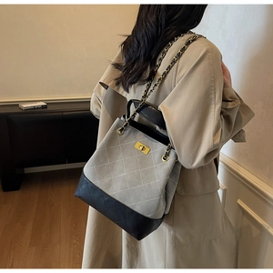 Quilted bucket bag with chain strap and contrast leather trim shown on model