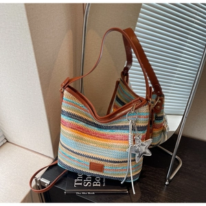 Detalle de bolso de cubo tejido con rayas coloridas y asas de cuero marron
