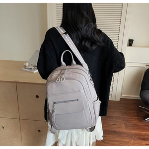 Detailed back view of a grey-purple PU leather backpack with chain and woven straps