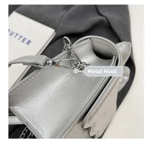 Detailed close-up of the silver handbag metal hook attachment and chain link