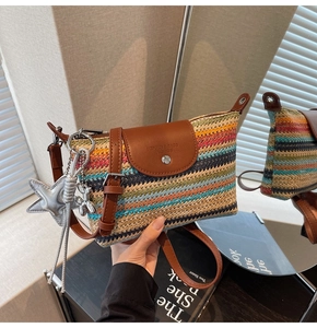 Detail der bunten gewebten Tasche mit brauner Lederklappe und silbernem Sternanhänger