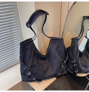 Close-up of navy denim tote bag featuring white contrast stitching and silver hardware