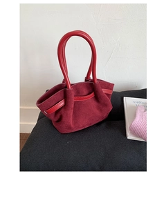 Close-up of the burgundy suede tote bag with contrast bright red leather handles