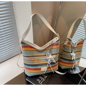 Detalle del bolso de hombro tejido colorido con correa blanca y colgante de estrella