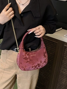 Sac hobo en velours bordeaux avec chaîne dorée et lettrage porté par une mannequin