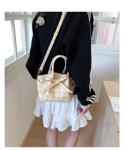 Sac seau vichy jaune avec détail nœud et bandoulière porté par le modèle