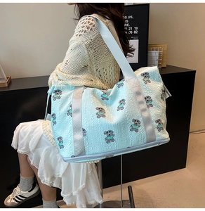 Blue travel bag with cartoon bear pattern and a separate bottom shoe compartment