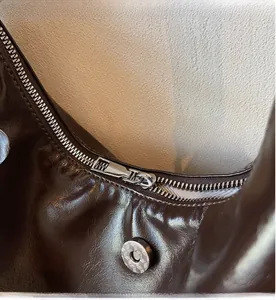 Détail du zip argenté et du fermoir magnétique sur le sac hobo en cuir café foncé