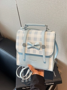 Blue and white plaid handbag with a bow decoration and metal handle hardware