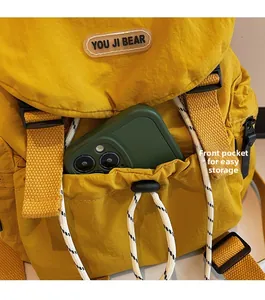 Gros plan d'un sac à dos en nylon jaune avec poche à cordon pratique et logo d'ours stylé