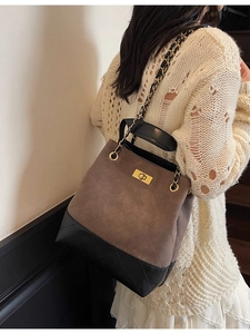Quilted chain bucket bag in brown and black leather mix shown on model in minimalist room
