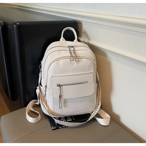 Close-up of white pebble leather backpack with silver chains and adjustable straps