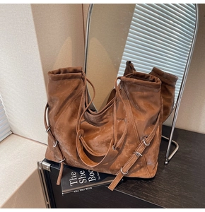 Detailed view of brown retro tote bag featuring vintage texture and silver metal buckles