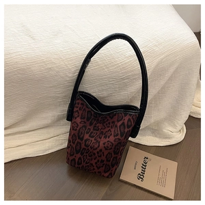 Detailed close-up of leopard print bucket bag texture and black leather top handle