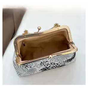 Detail view of the floral jacquard handbag interior with zip pocket and metal clasp