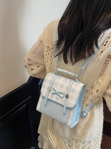 Blue and white plaid mini backpack with bow detail worn on model's back