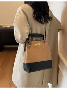 Quilted crossbody bucket bag in brown and black with gold chain strap on model