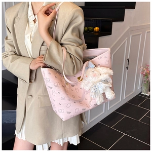 Detail of pink lychee textured tote bag with cute animal patterns and rabbit charm