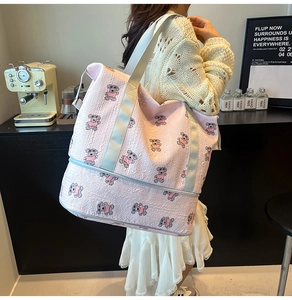Detail of pink travel bag showing waterproof textured fabric and cartoon puppy print