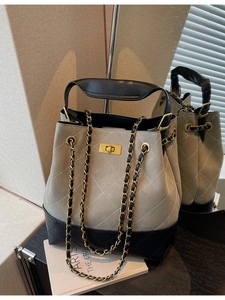 Quilted bucket bag with chain strap and metal lock in beige and black color block