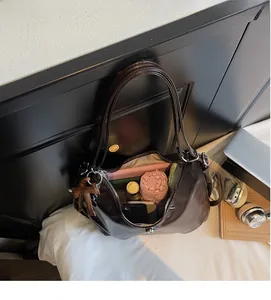 Détail de l'intérieur spacieux du sac fourre-tout en cuir marron avec objets quotidiens