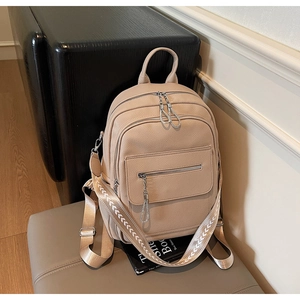 Detail of beige lychee texture backpack with functional silver zippers and woven strap