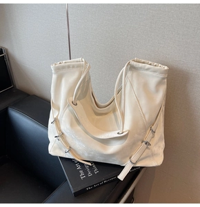 Detail of off-white hobo bag with soft leather texture and adjustable silver buckle strap